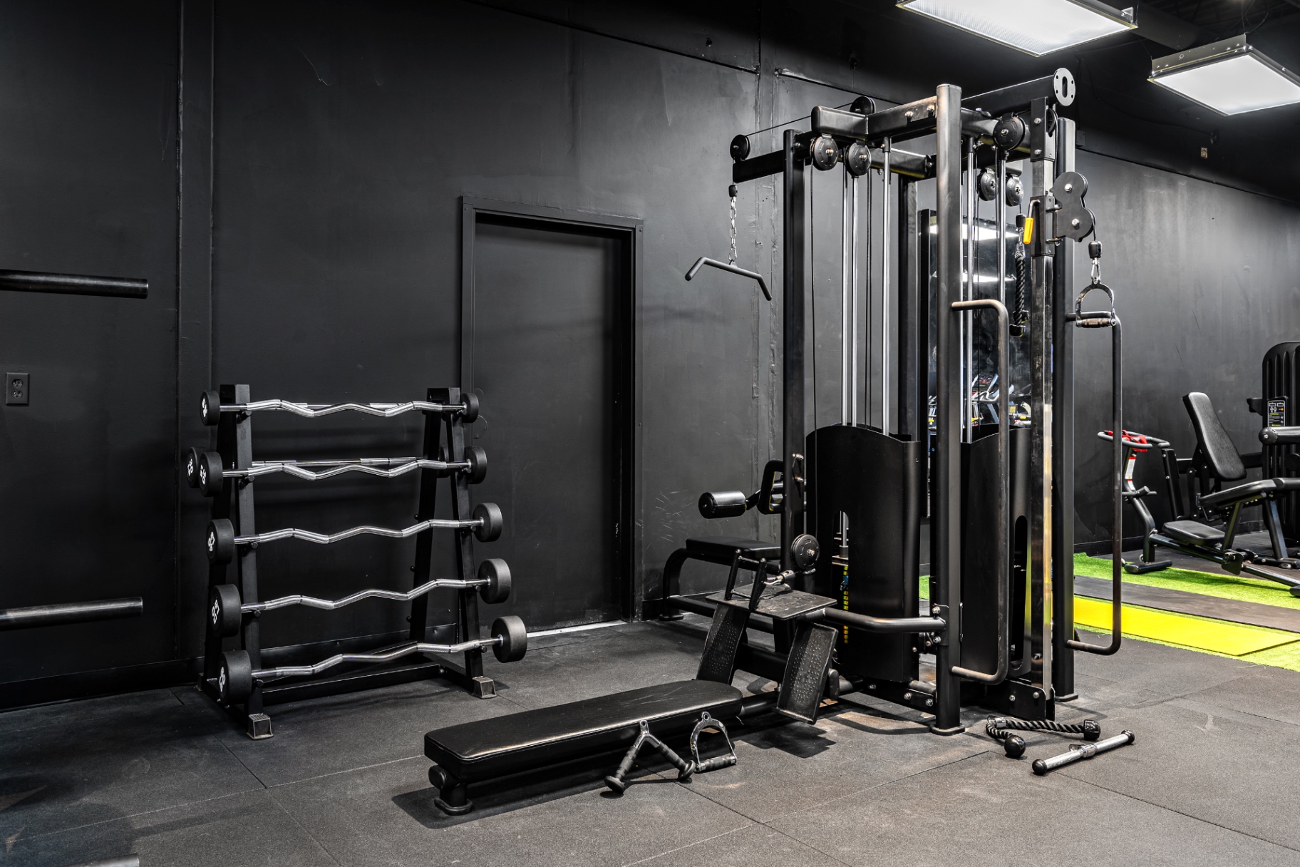 Multi-station cable tower and EZ-curl bar rack at Elk Fitness
