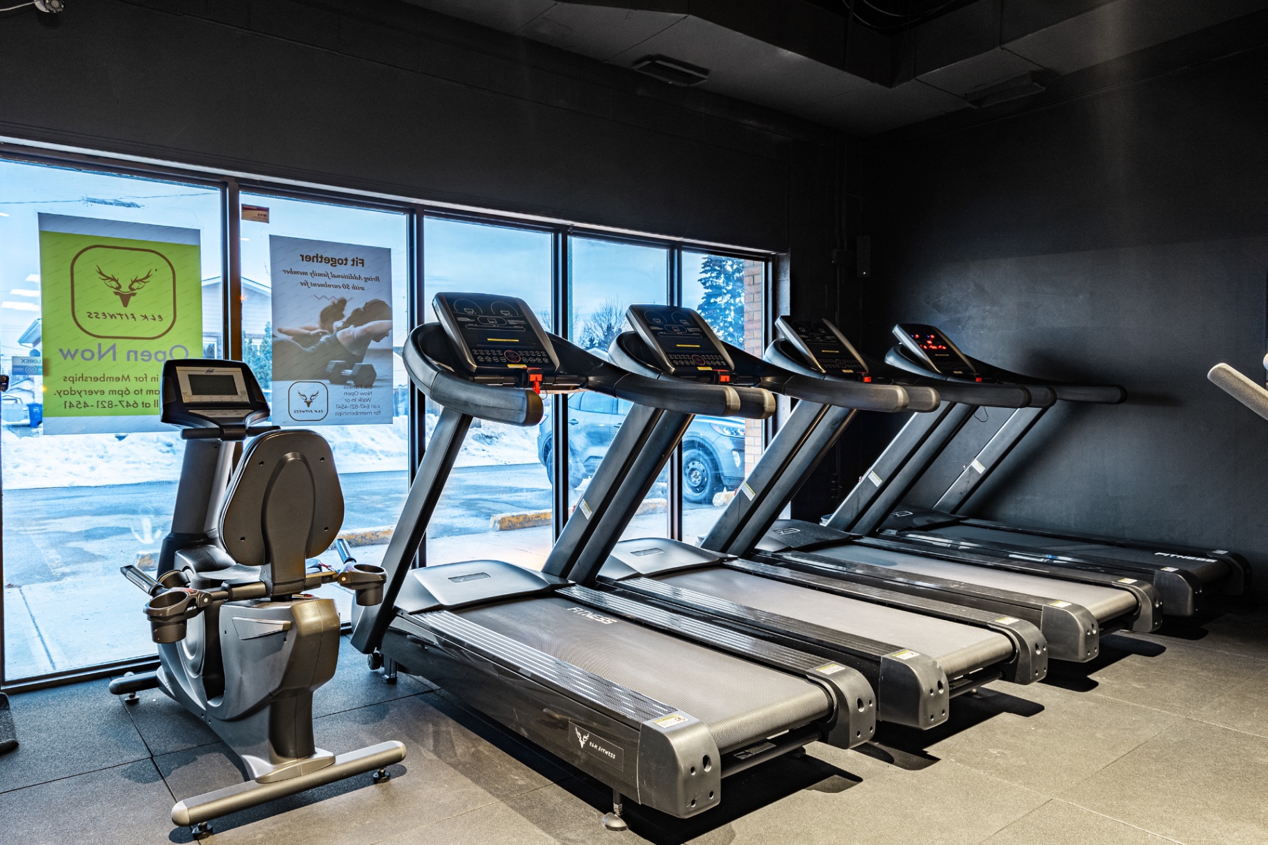 Treadmill bay with floor-to-ceiling windows and Open Now signage